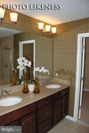4233 Forge Road Perry Hall, MD 21128 - Photo 26 of 28 a bathroom with a double vanity sink and a mirror
