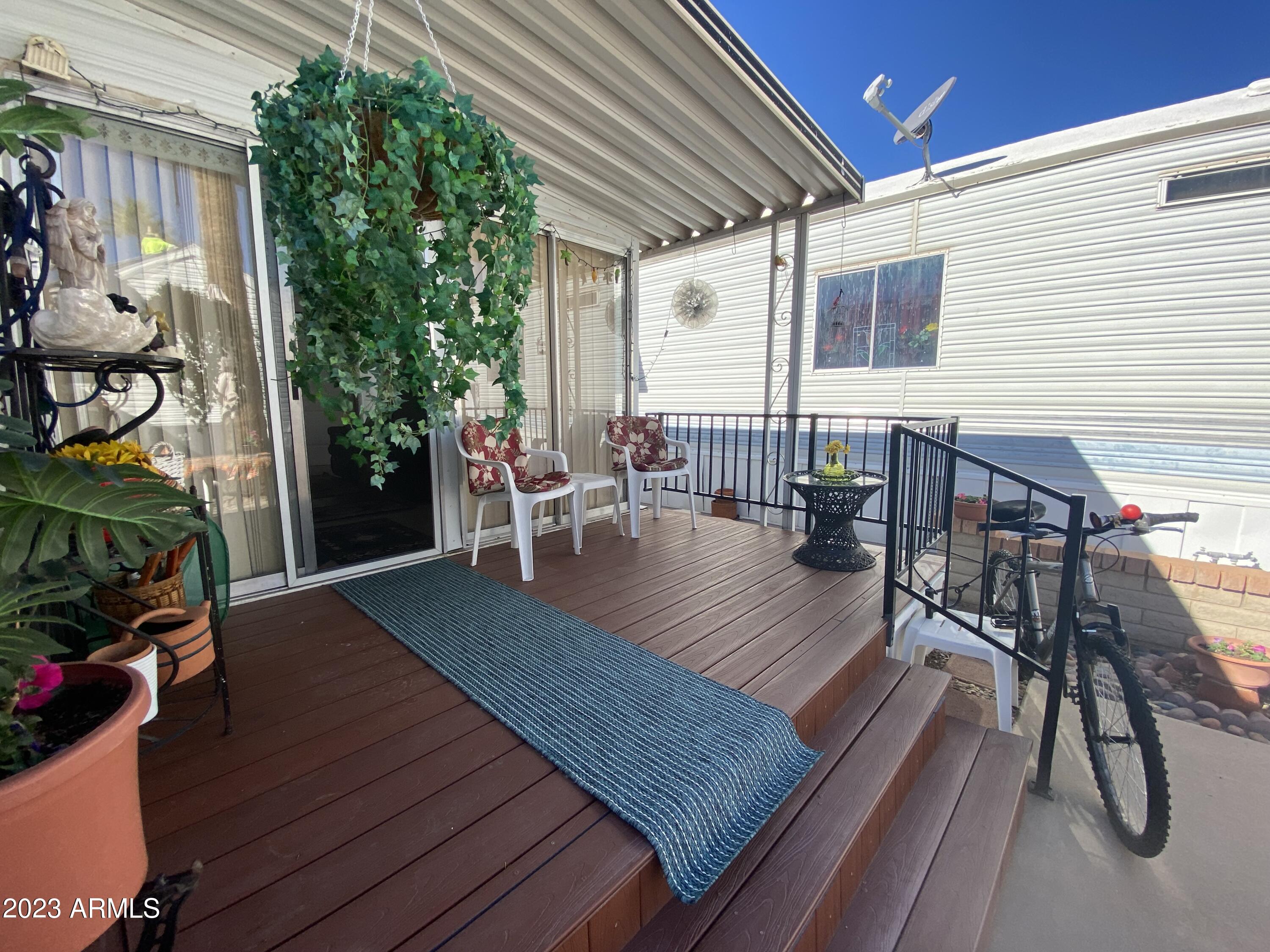 3301 South Goldfield Road Apache Junction, AZ 85119 - Photo 36 of 45 a view of a patio with table and chairs with wooden floor and fence