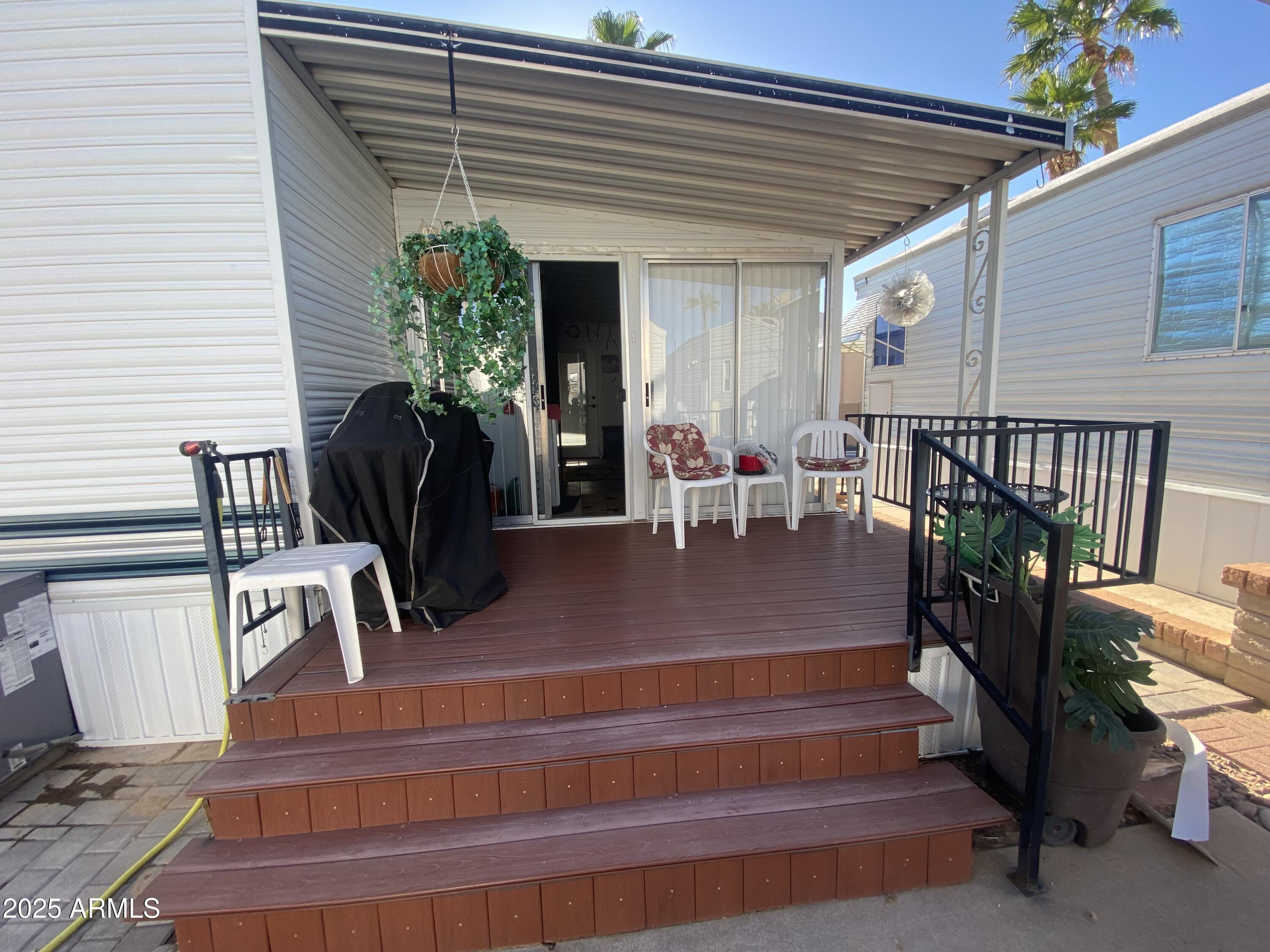 3301 South Goldfield Road Apache Junction, AZ 85119 - Photo 42 of 45 a view of a patio with table and chairs potted plants and floor to ceiling window