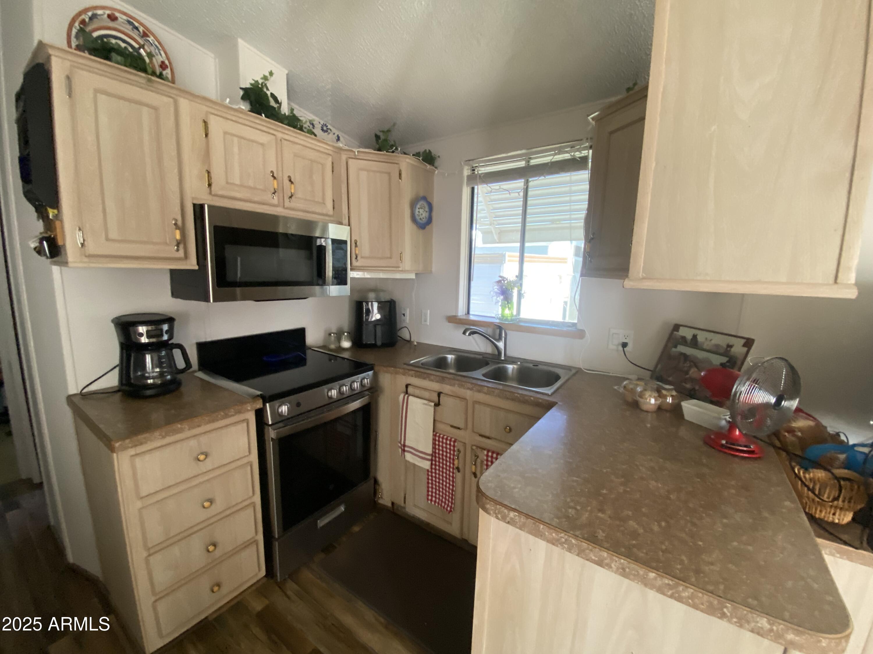 3301 South Goldfield Road Apache Junction, AZ 85119 - Photo 6 of 45 a kitchen with a stove a sink and a microwave