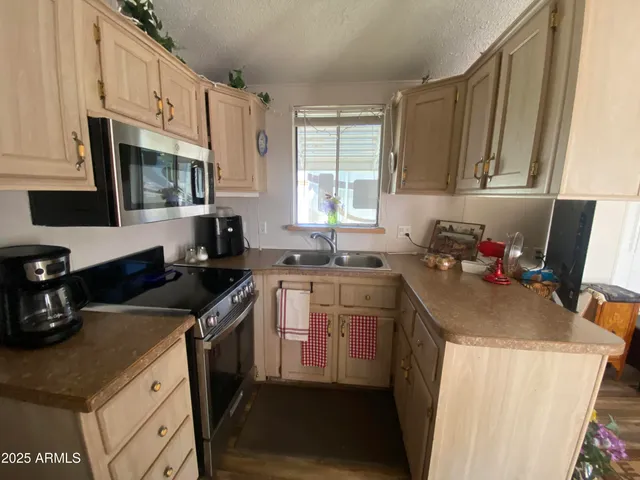 a kitchen with granite countertop a sink stove and cabinets