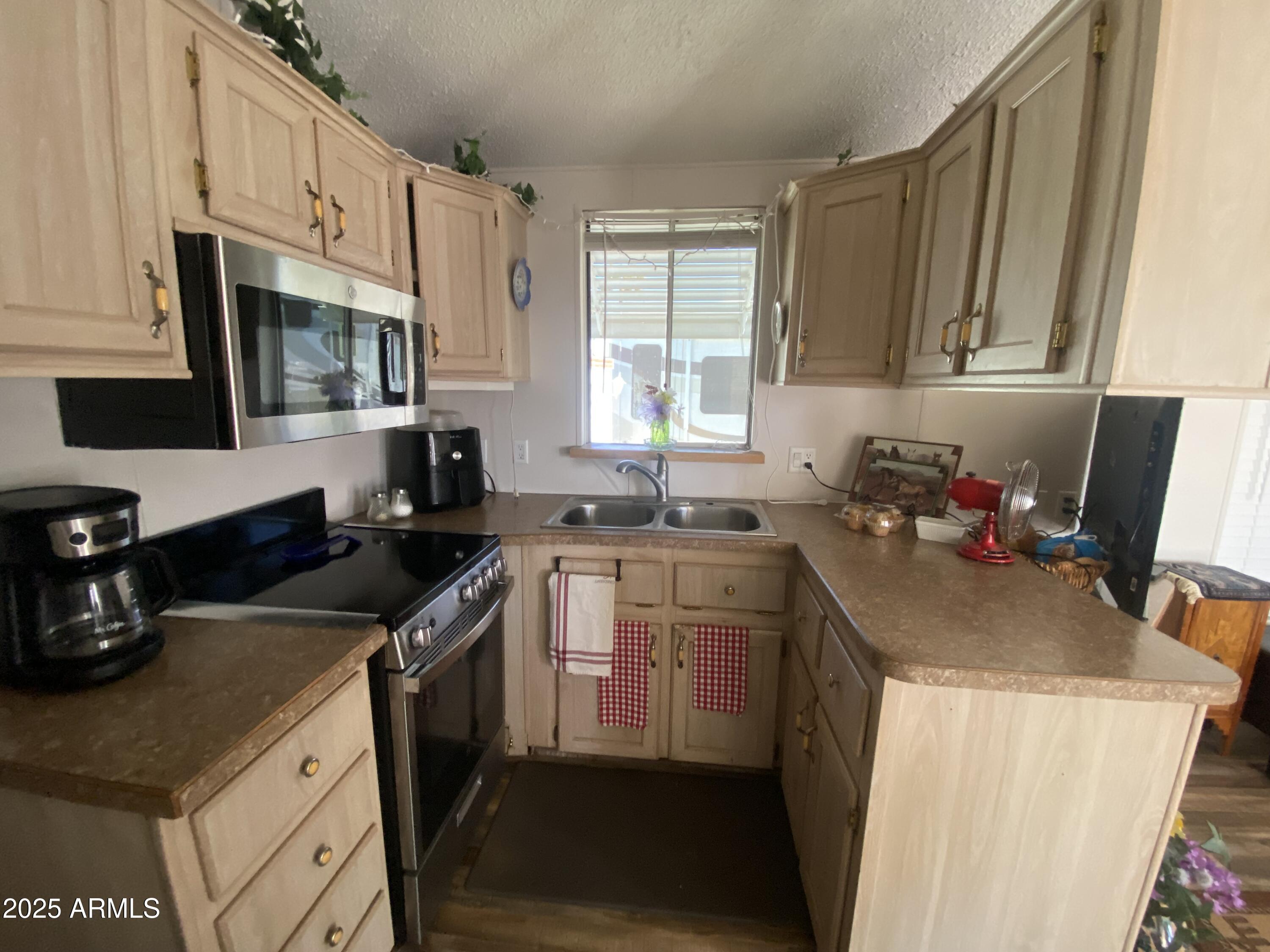 3301 South Goldfield Road Apache Junction, AZ 85119 - Photo 8 of 45 a kitchen with granite countertop a sink stove and cabinets
