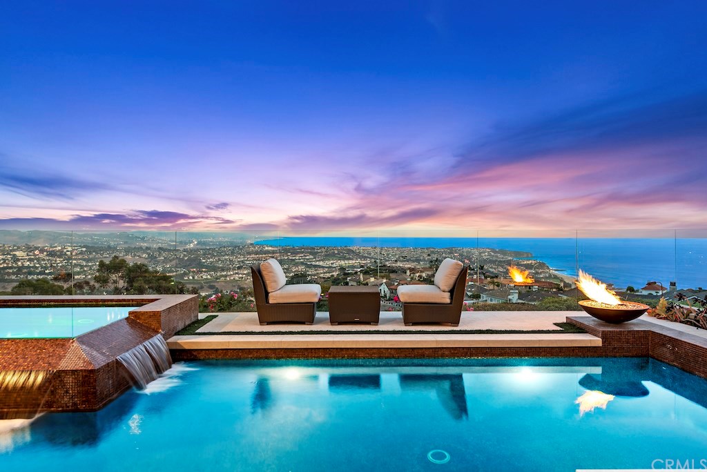 Positioned atop a scenic bluff in the prestigious guard-gated enclave of Monarch Point, this contemporary estate enjoys breathtaking whitewater panoramas of the Pacific, renowned coastline, city lights, and Ritz Carlton from nearly every room.