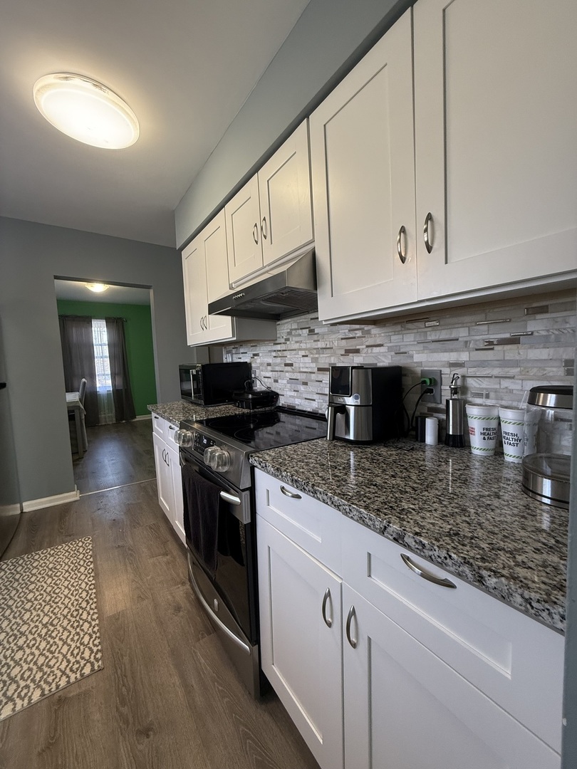 14280 Linder Avenue Midlothian, IL 60445 - Photo 7 of 19 a kitchen with stainless steel appliances granite countertop a stove a sink and a microwave
