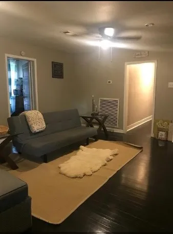 a living room with couch and wooden floor
