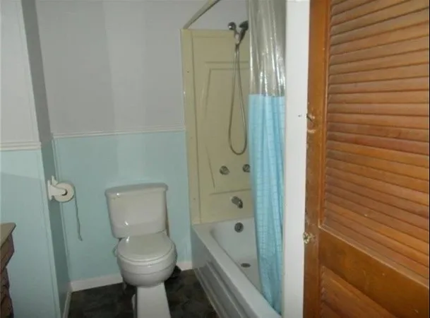 a bathroom with a toilet and shower