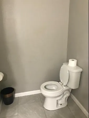 a white toilet sitting next to a white cabinet