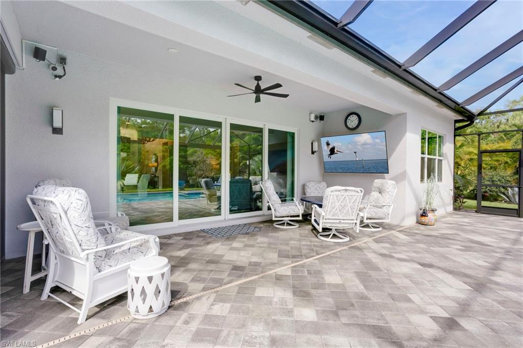 11413 Jacaranda Drive Naples, FL 34120 - Photo 30 of 50 a room with patio furniture and a floor to ceiling window