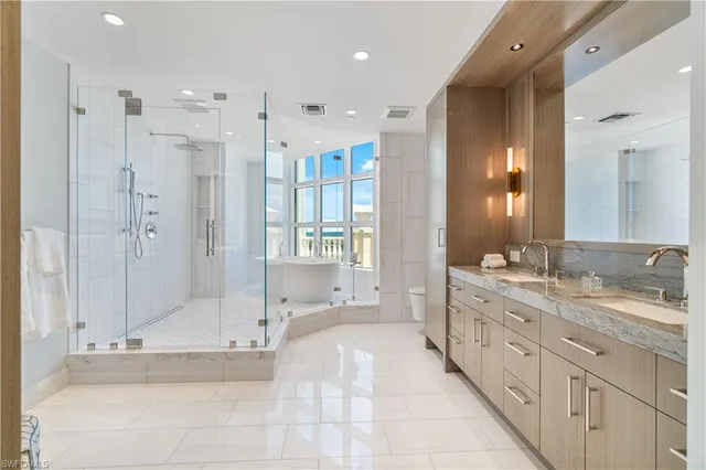 a large bathroom with a glass shower door and a mirror