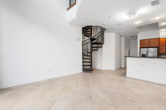 a view of a kitchen with fridge and stairs