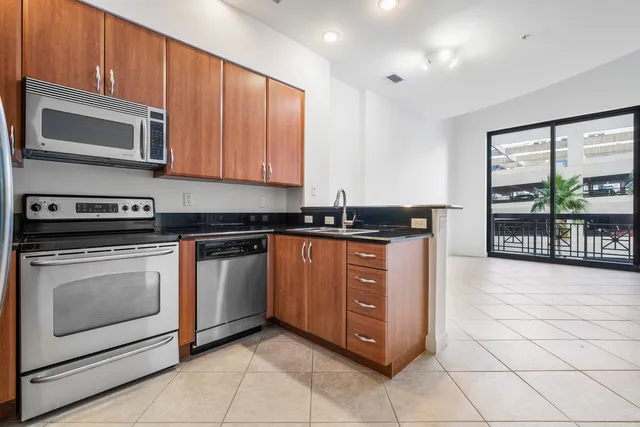 a kitchen with stainless steel appliances granite countertop a stove a microwave and a sink