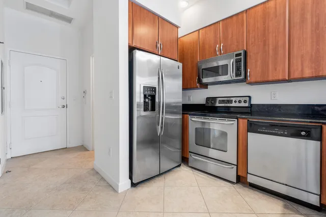 a kitchen with stainless steel appliances granite countertop a refrigerator and a stove top oven