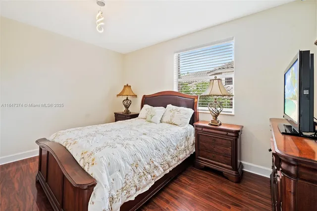 a bedroom with a bed and a lamp on dresser