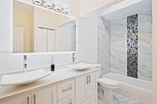 a large bedroom with a large bed and dresser with mirror