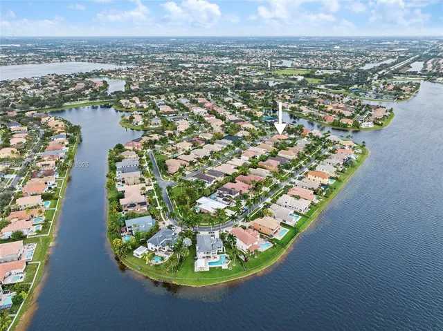 an aerial view of residential houses with outdoor space and trees