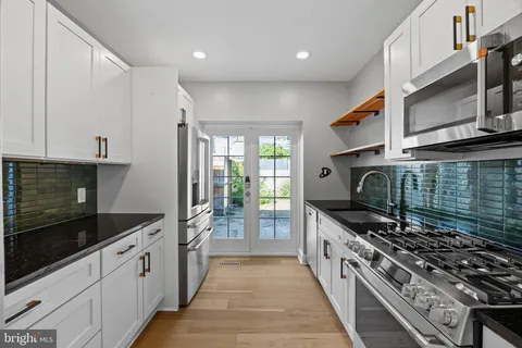 a kitchen with stainless steel appliances granite countertop a stove and a microwave