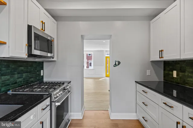 a kitchen with granite countertop white cabinets and stainless steel appliances