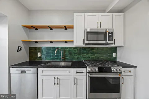 a close view of a sink a counter space and utility room