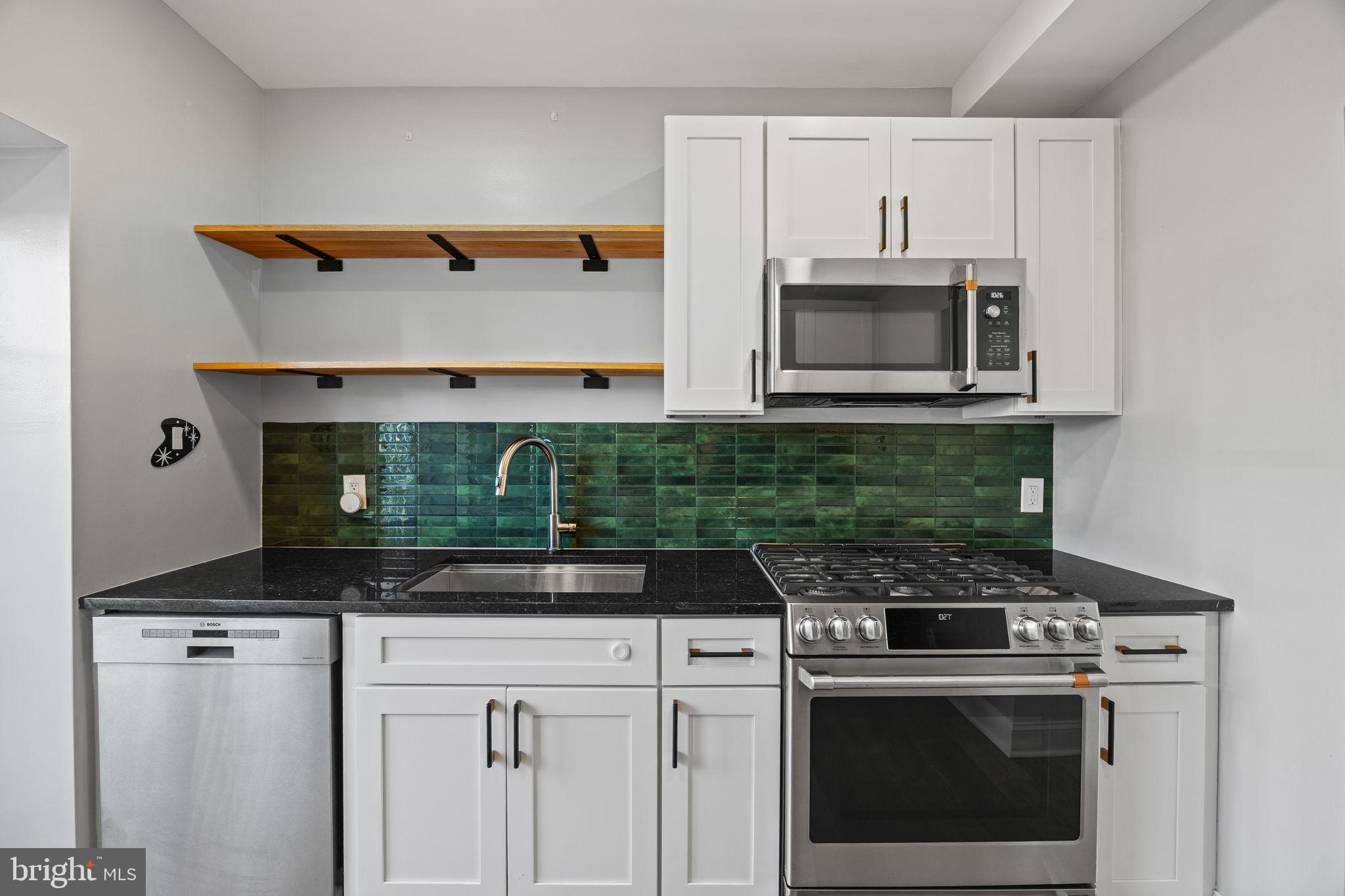 2026 North Lawrence Street Philadelphia, PA 19122 - Photo 13 of 34 a kitchen with granite countertop white cabinets and stainless steel appliances