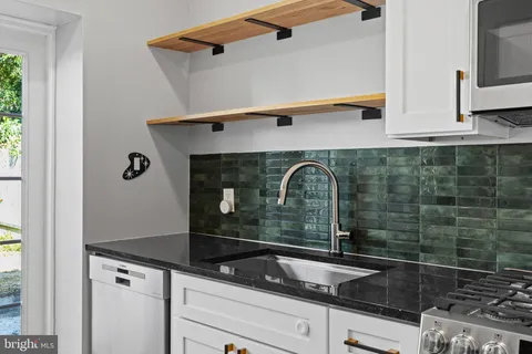 a kitchen with granite countertop a refrigerator and a sink