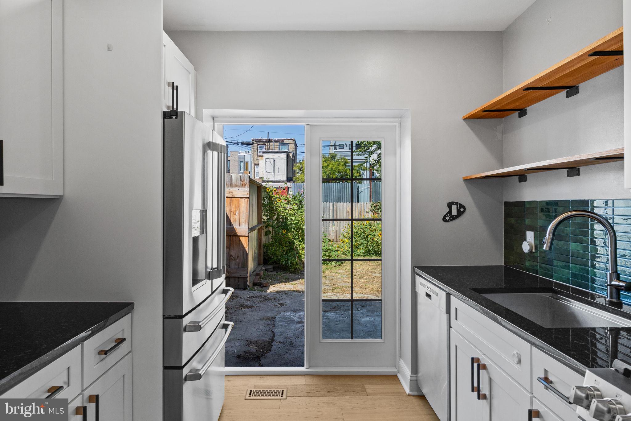 2026 North Lawrence Street Philadelphia, PA 19122 - Photo 16 of 34 a kitchen with granite countertop a stove a sink and a refrigerator