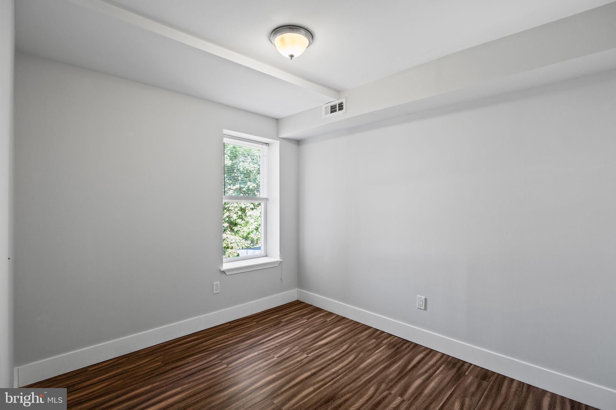 2026 North Lawrence Street Philadelphia, PA 19122 - Photo 20 of 34 an empty room with wooden floor and windows