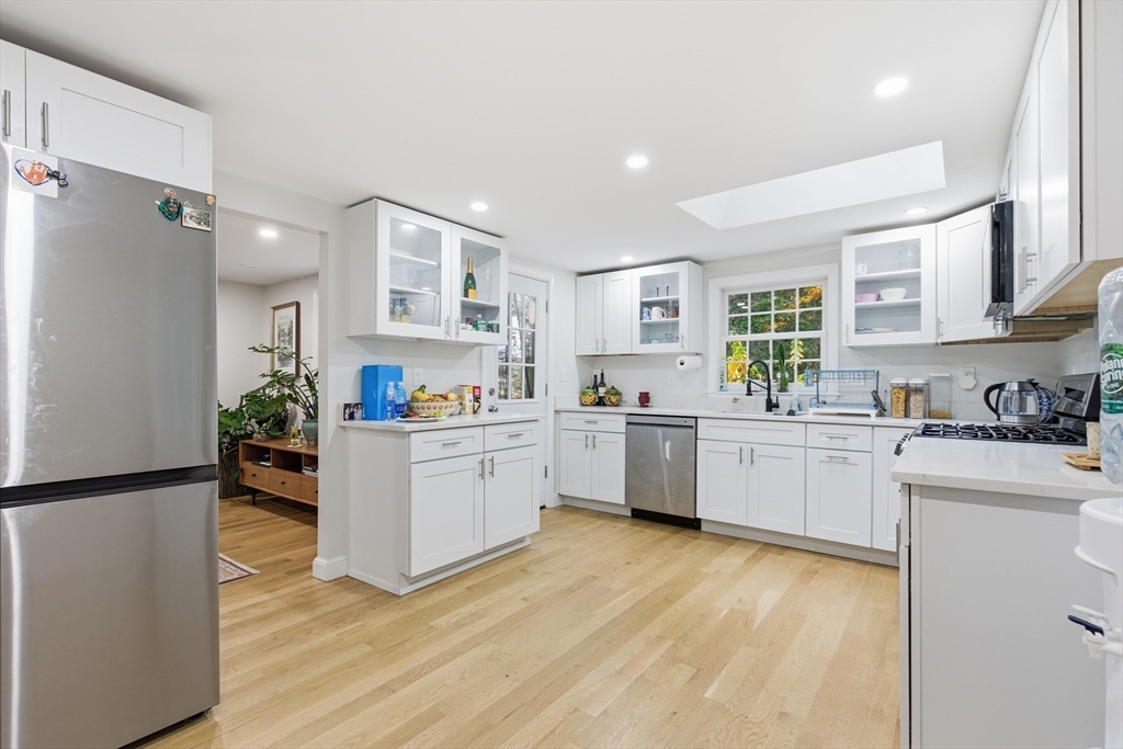 24 Woodland Road Sudbury, MA 01776 - Photo 20 of 42 a kitchen with a refrigerator and white cabinets