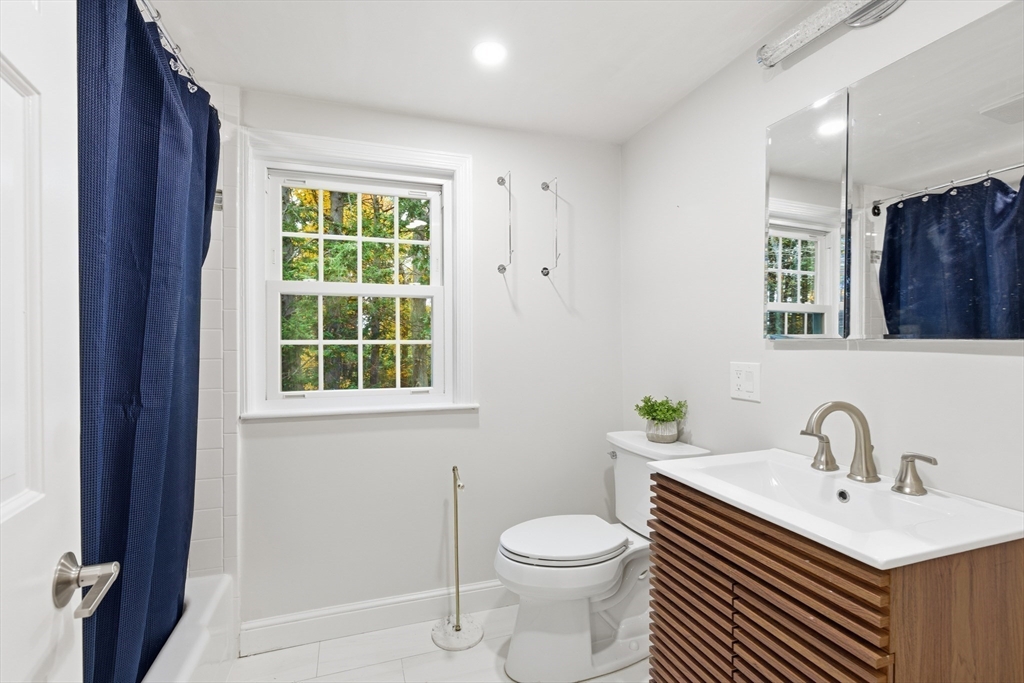 24 Woodland Road Sudbury, MA 01776 - Photo 31 of 42 a bathroom with a toilet a sink and a window