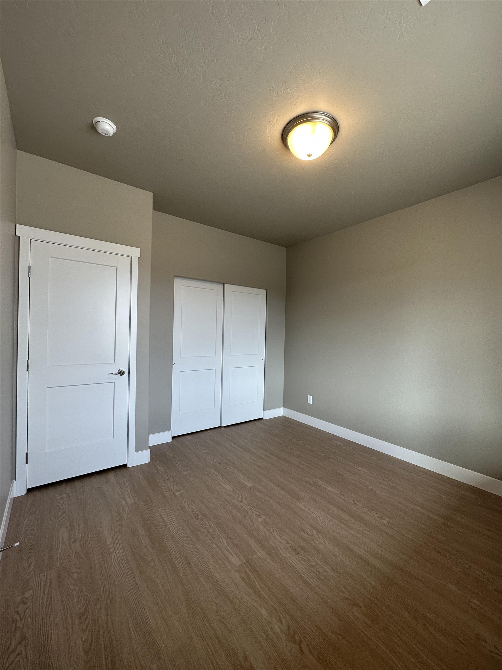 2456 Ross Road Grand Junction, CO 81505 - Photo 3 of 11 an empty room with wooden floor and windows