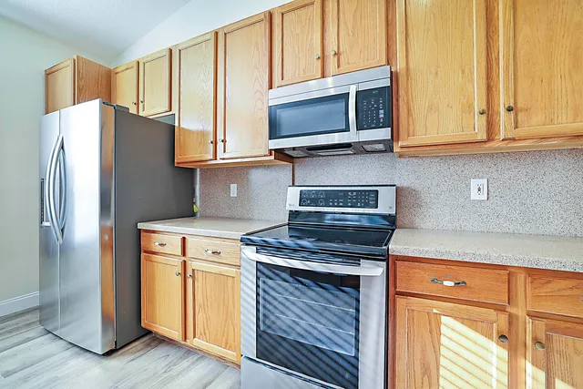 a kitchen with stainless steel appliances granite countertop a refrigerator stove and microwave