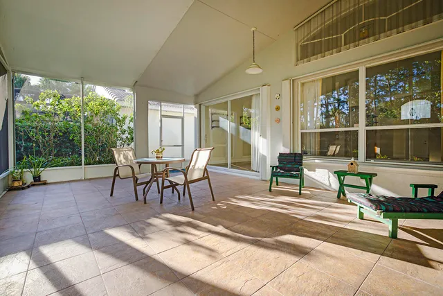 a view of a patio with table and chairs with plants and wooden fence