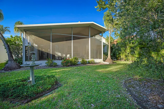 a view of a backyard with potted plants and a large tree