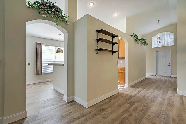 a view of a hallway with wooden floor and a living room