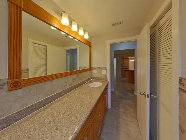 a bathroom with a tub a double vanity sink and mirror