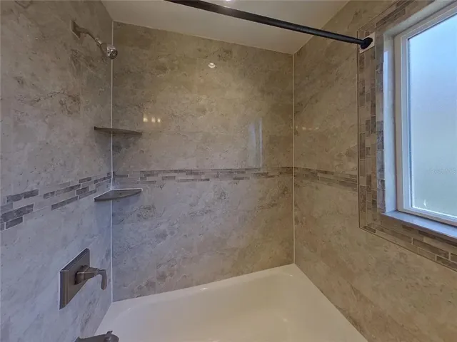 a bathroom with a shower and a bath tub