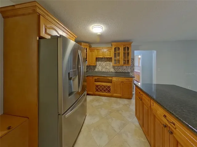 a kitchen with stainless steel appliances granite countertop a refrigerator and a sink