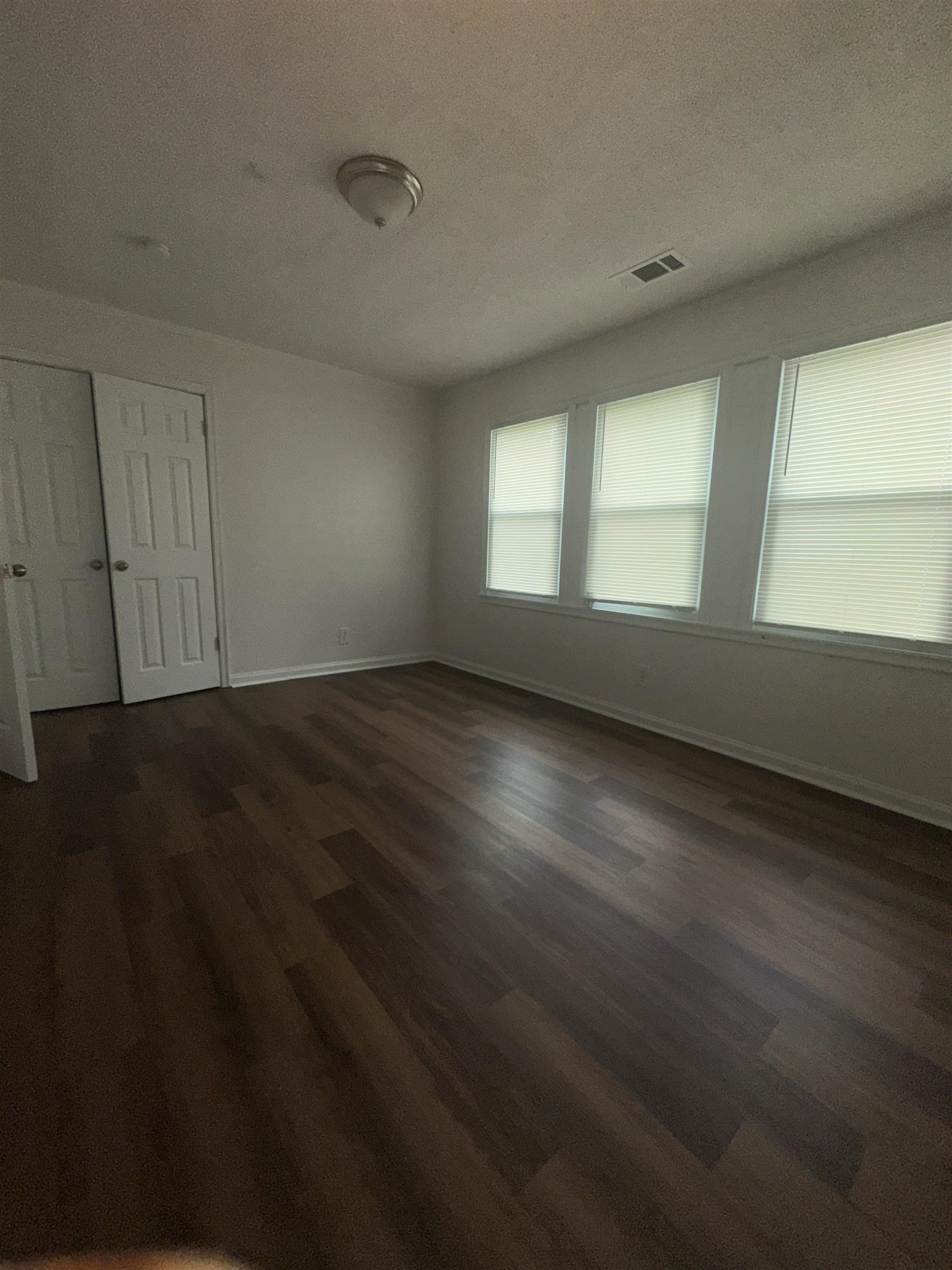 4545 Verne Road Memphis, TN 38117 - Photo 9 of 10 Room featuring wood-finish flooring, white walls, and multiple windows with blinds