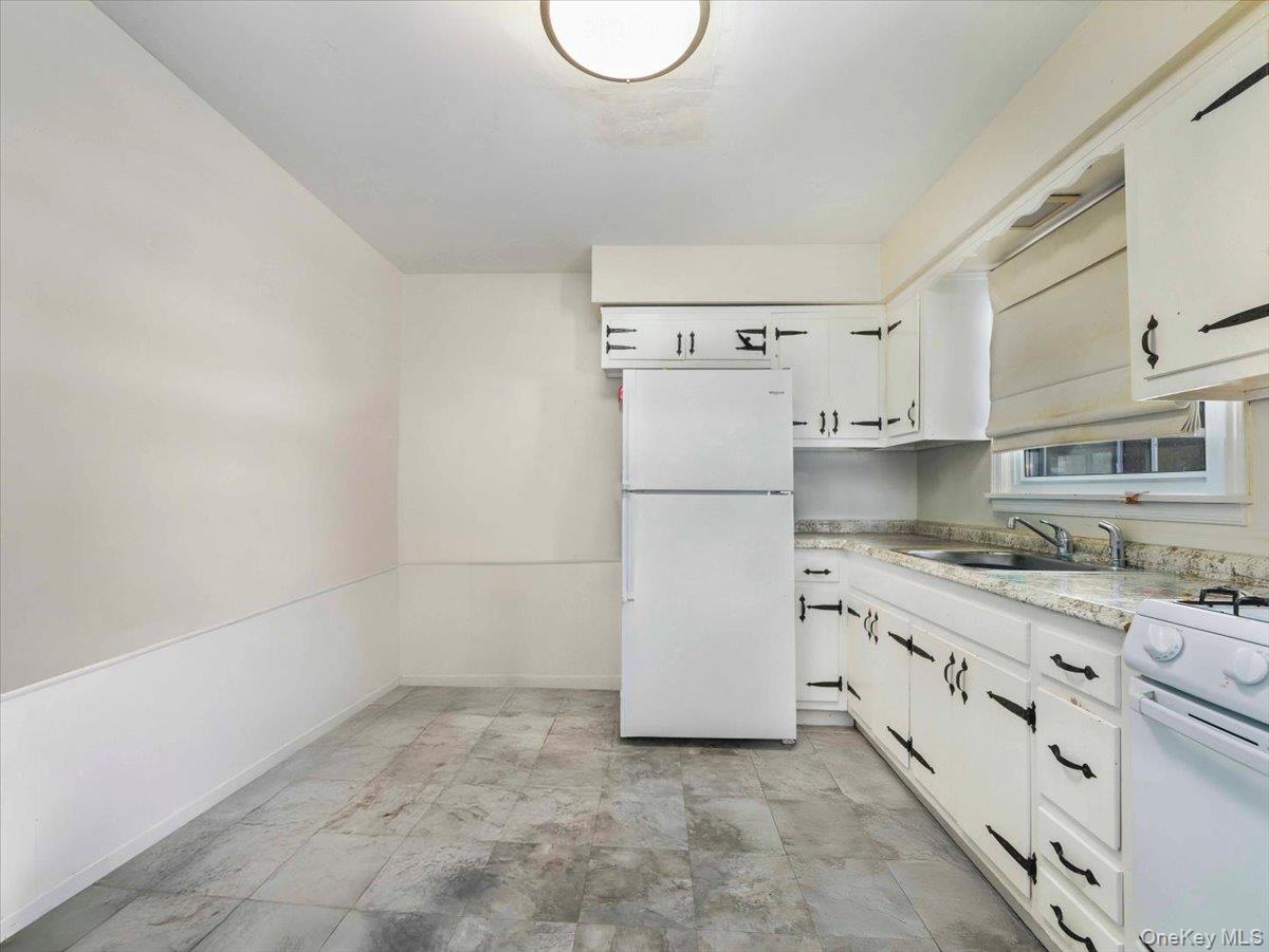 61 Rolling Ridge Road New City, NY 10956 - Photo 38 of 43 a kitchen with granite countertop a refrigerator a stove a sink and white cabinets