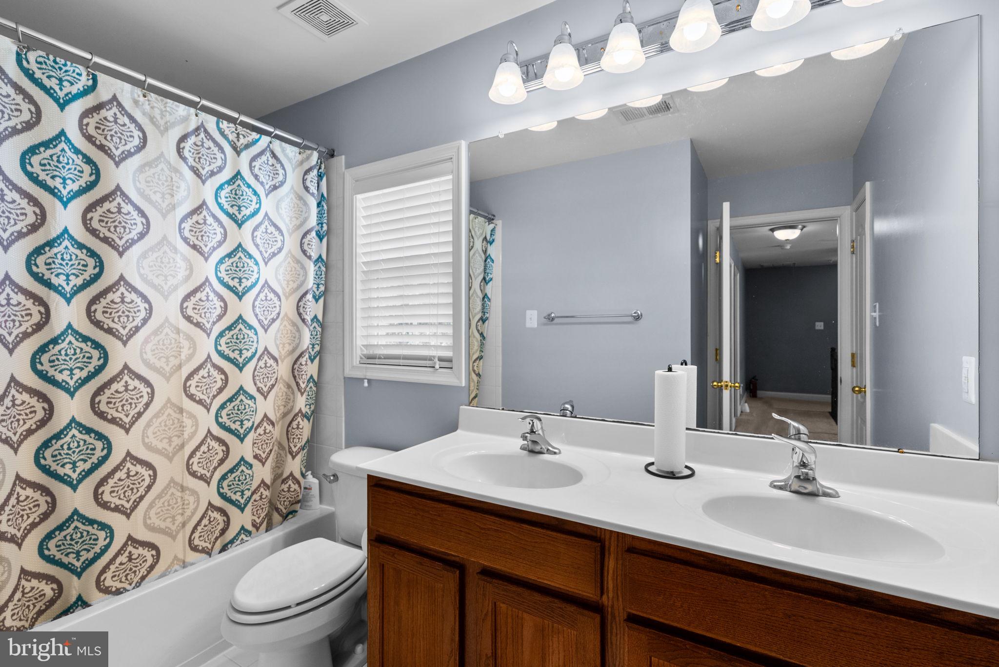8301 Cedar View Court Clinton, MD 20735 - Photo 21 of 32 a bathroom with a double vanity sink mirror and toilet