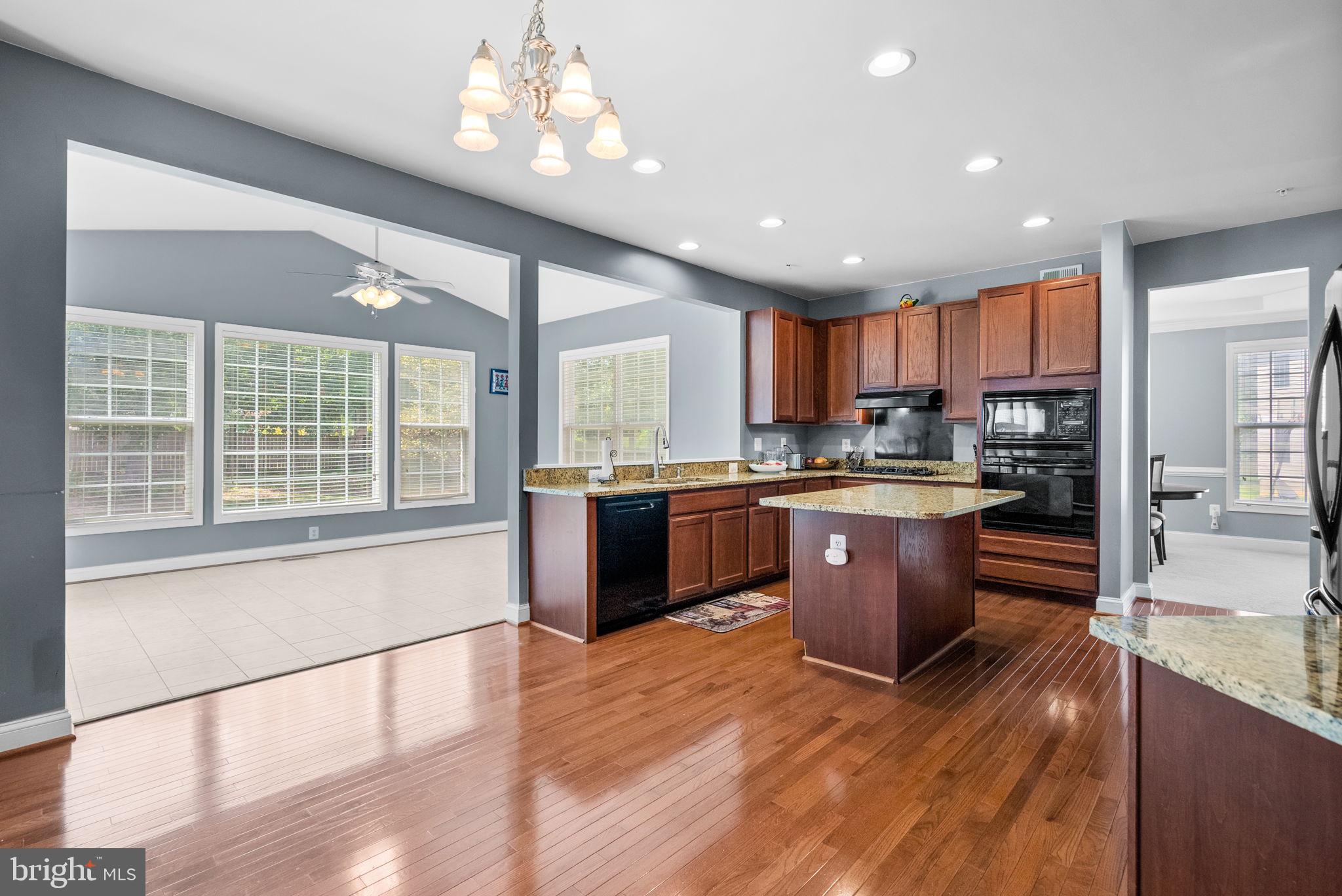 8301 Cedar View Court Clinton, MD 20735 - Photo 8 of 32 a kitchen with stainless steel appliances granite countertop a refrigerator a sink dishwasher a kitchen island with cabinets and wooden floor