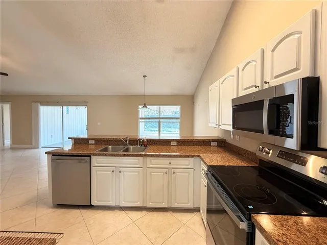 a kitchen with stainless steel appliances granite countertop a sink and a stove