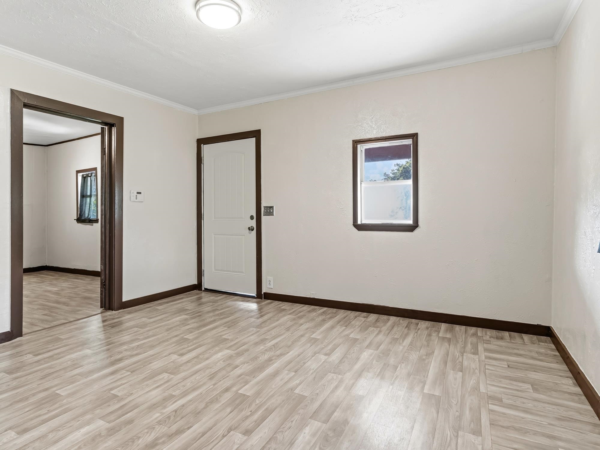 737 9th Street Port Arthur, TX 77640 - Photo 6 of 20 a view of an empty room with wooden floor and a window