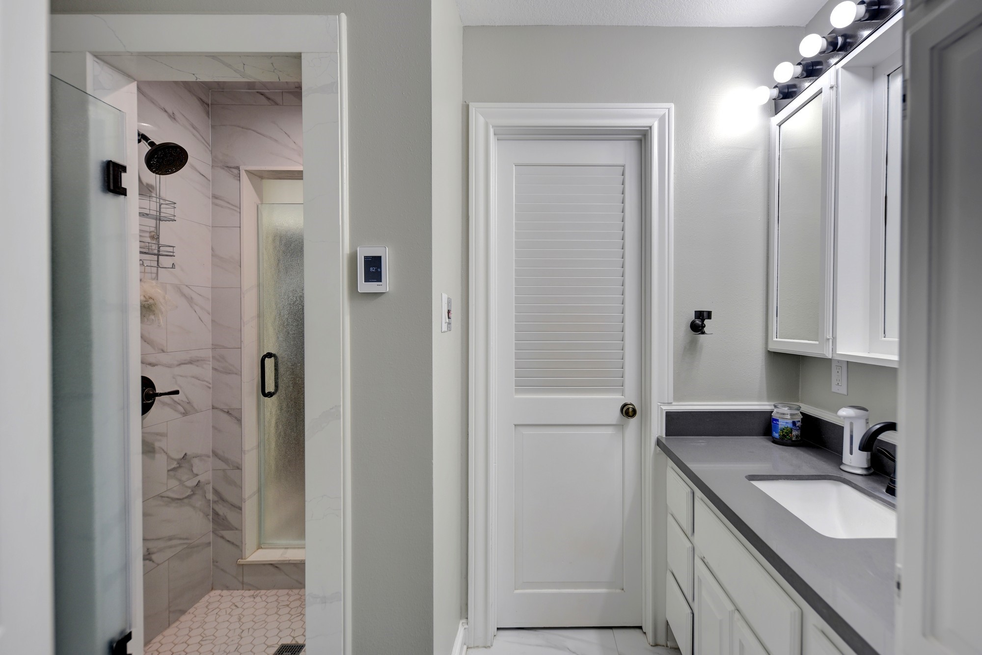 1950 Country Club Road Brenham, TX 77833 - Photo 30 of 39 a bathroom with a granite countertop sink two mirror and shower