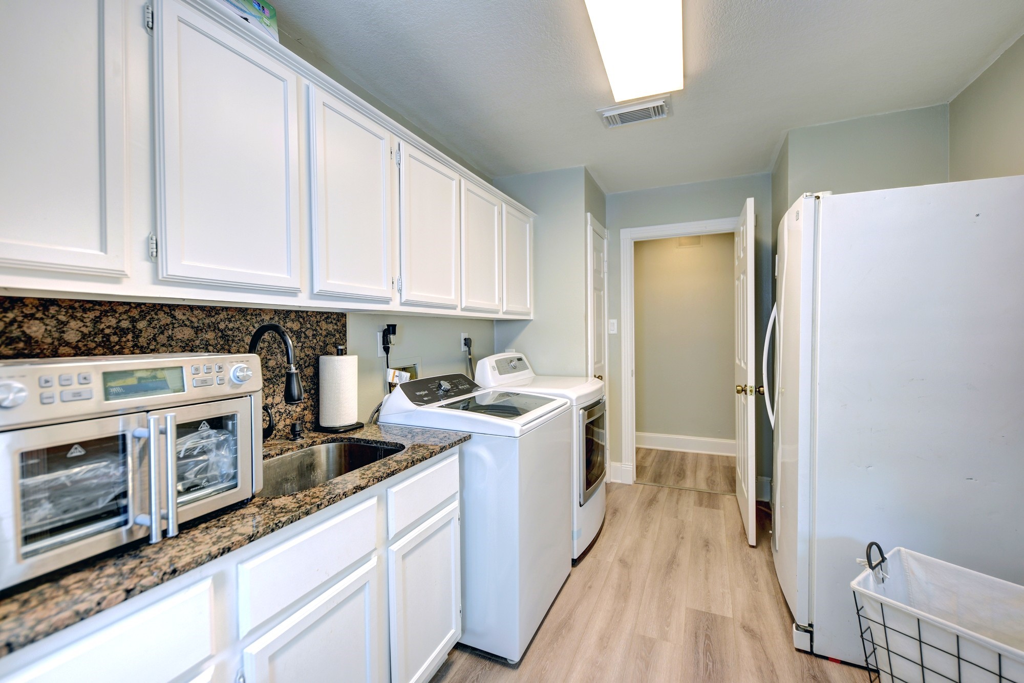 1950 Country Club Road Brenham, TX 77833 - Photo 33 of 39 a kitchen with a stove a sink and a refrigerator