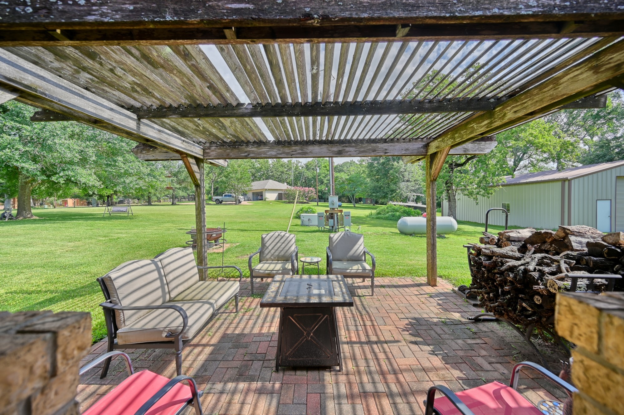 1950 Country Club Road Brenham, TX 77833 - Photo 37 of 39 a view of a patio with a table chairs and a backyard