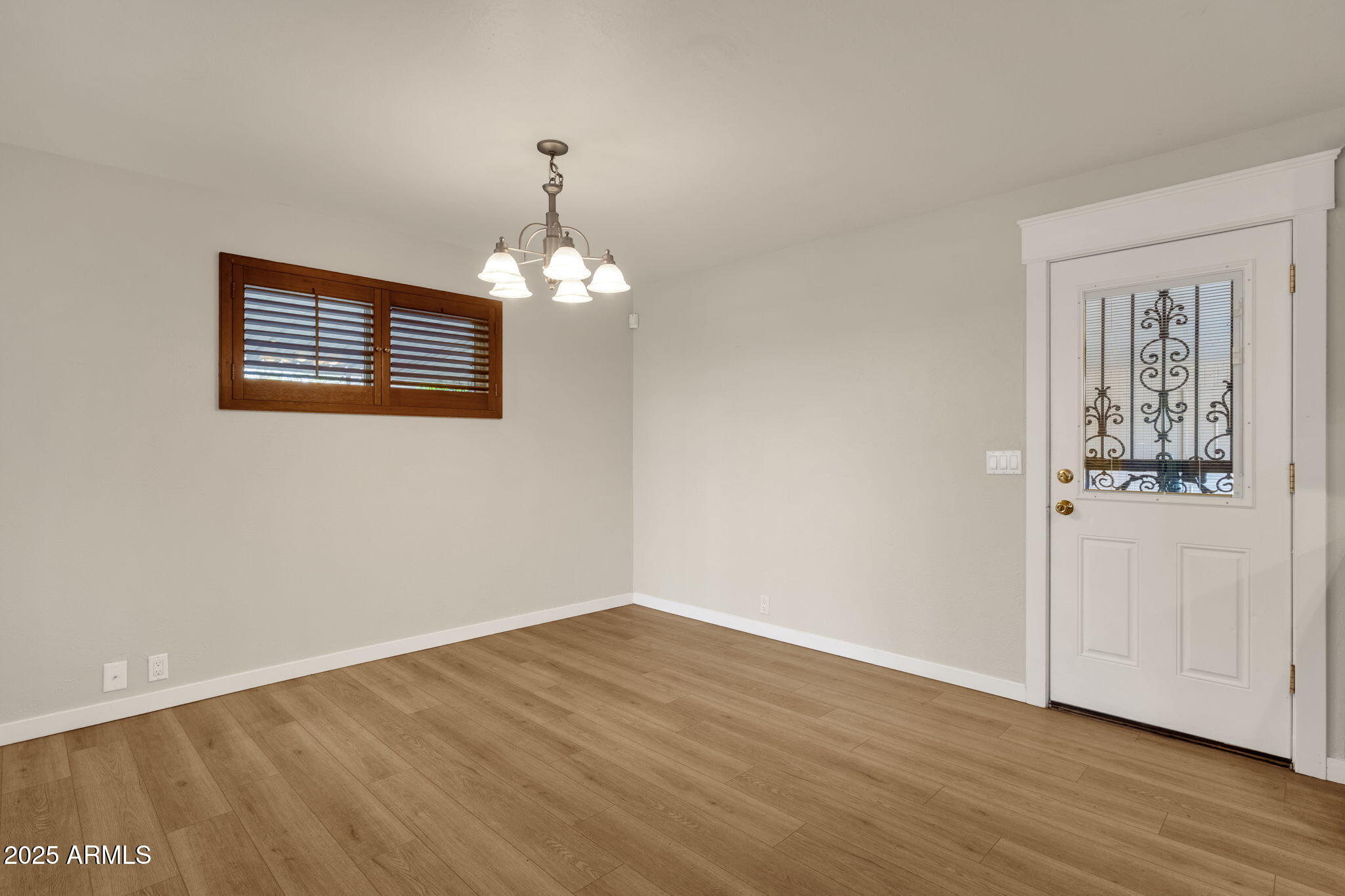 2139 South La Rosa Drive Tempe, AZ 85282 - Photo 12 of 29 a view of an empty room with wooden floor and a window