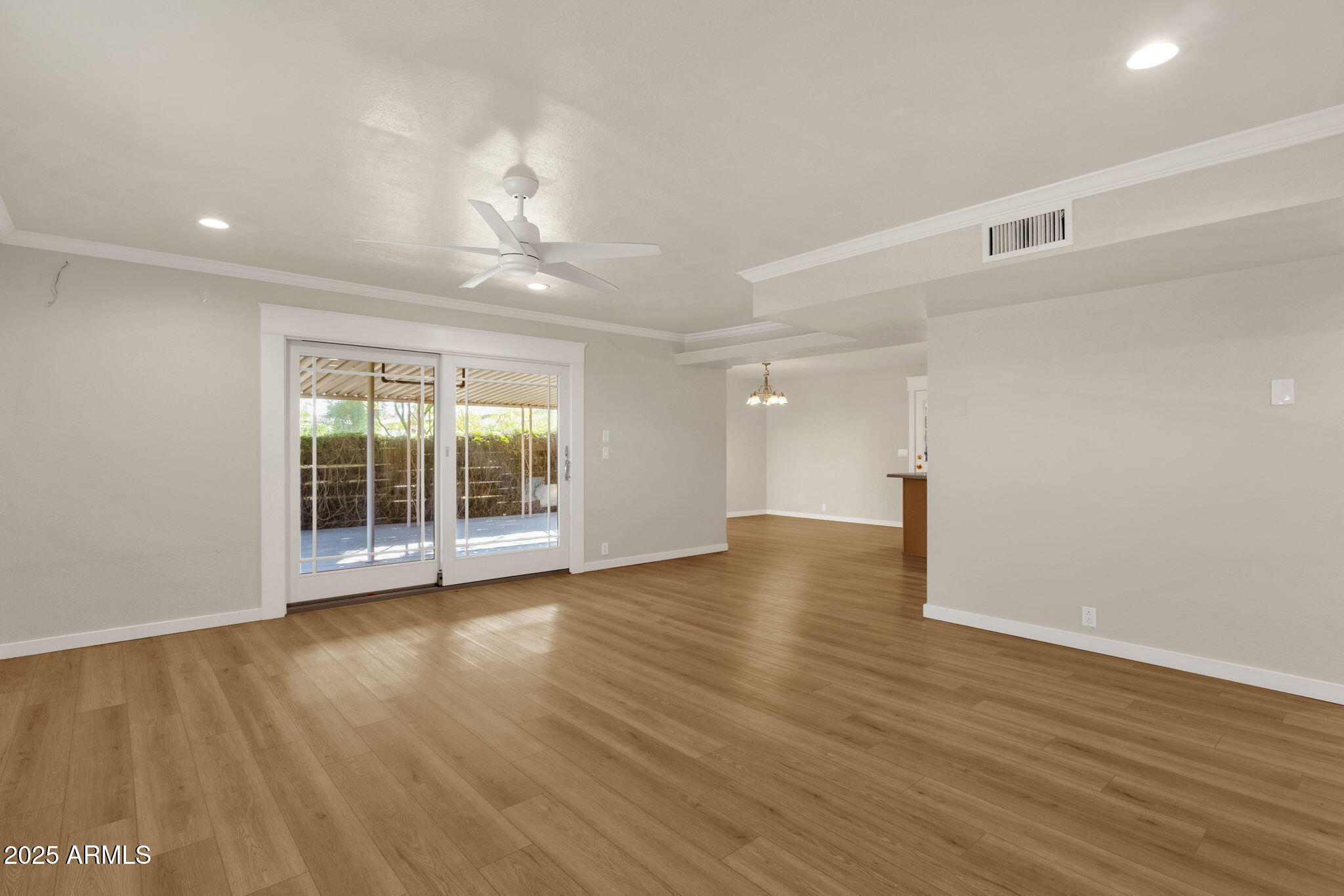 2139 South La Rosa Drive Tempe, AZ 85282 - Photo 4 of 29 a view of an empty room with wooden floor and a window