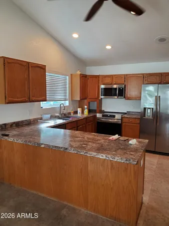 a kitchen with stainless steel appliances granite countertop a sink a stove and a refrigerator