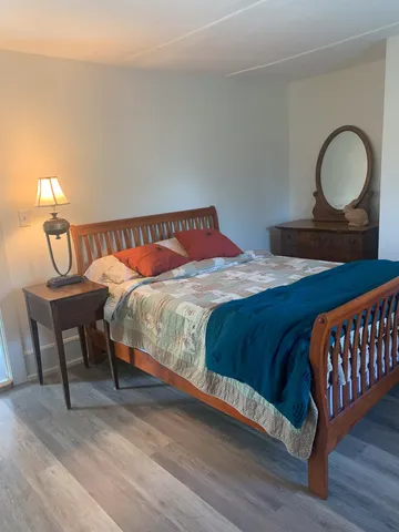 a bedroom with a bed and a painting on the wall