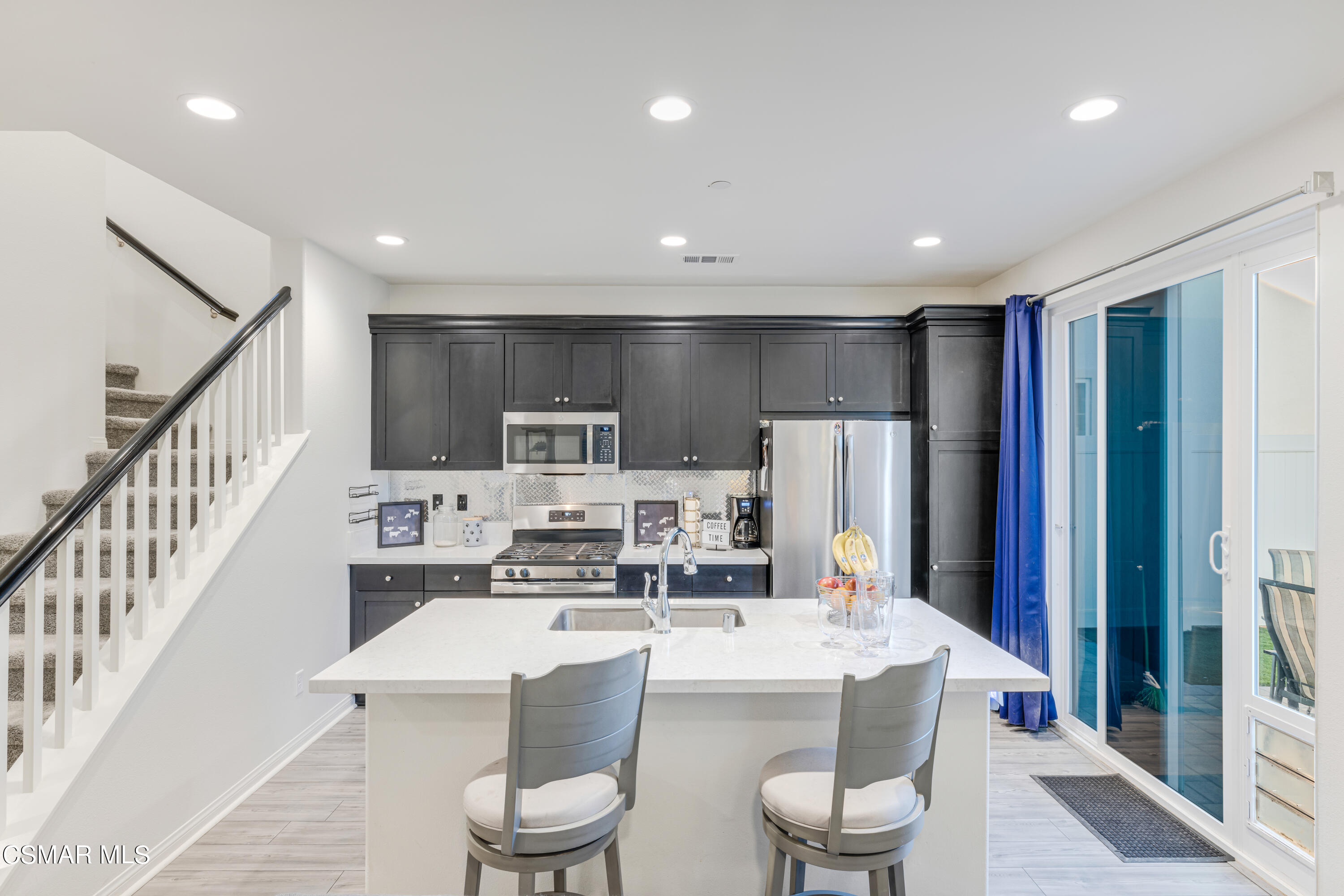 278 Hydrangea Street Fillmore, CA 93015 - Photo 8 of 22 a large kitchen with a table chairs refrigerator and cabinets